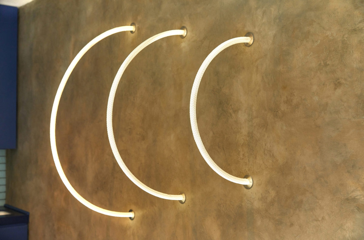 Neon arcs on a gold plaster wall at Gusto Oxford Street