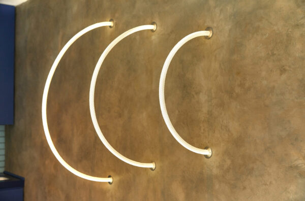 Neon arcs on a gold plaster wall at Gusto Oxford Street