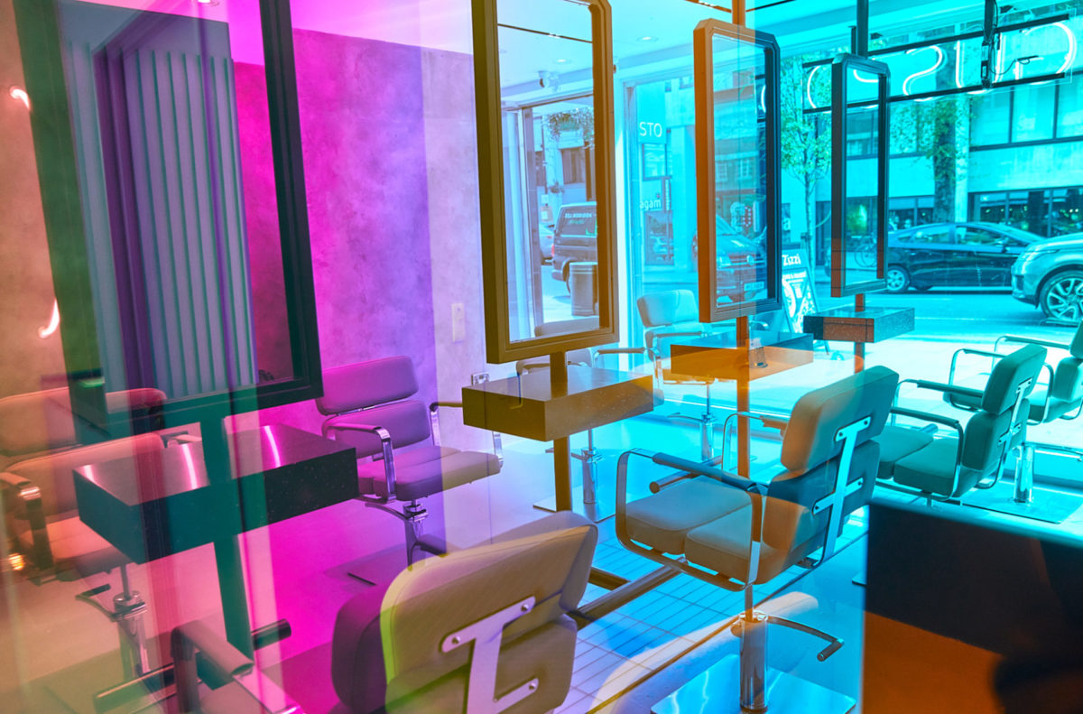 Pink and blue glass screens between the styling stations at Gusto Covent Garden
