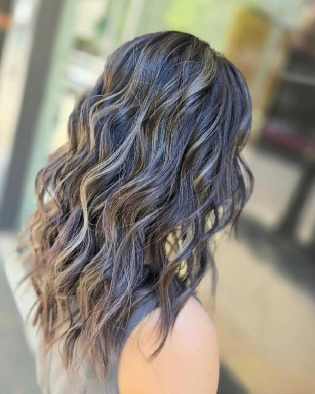 Dark hair with soft blended highlights and loose waves, coloured at Gusto Hair, London