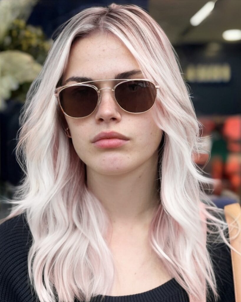 Platinum blonde with pastel pink tones and long layers at Gusto Hair London