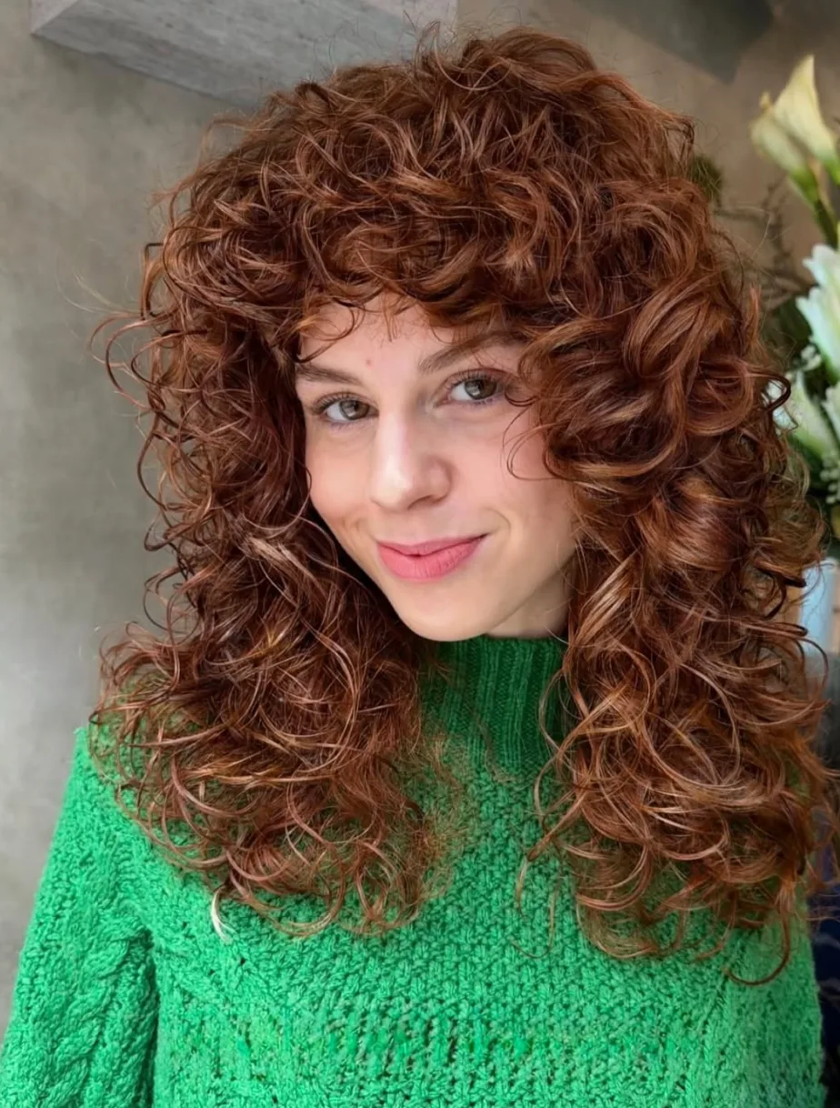 Copper curls with a full curly fringe at Gusto Hair, London