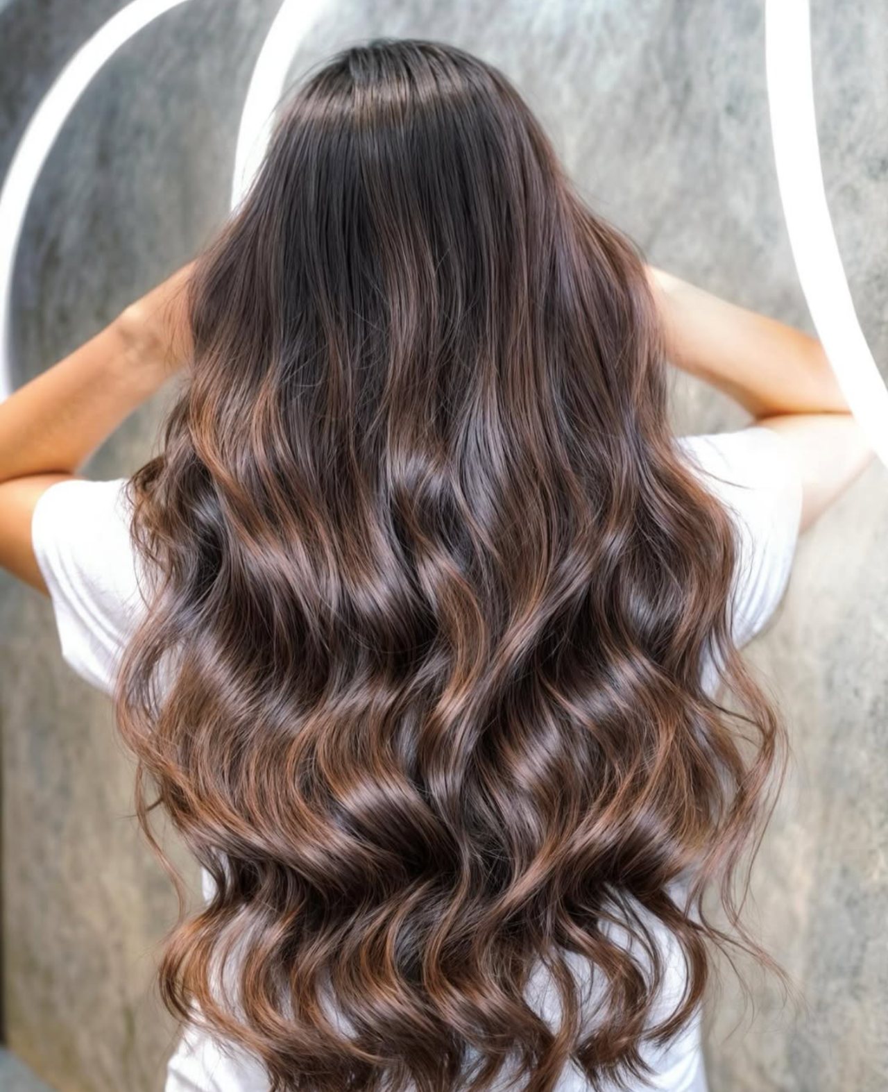 Long wavy hair with soft brunette balayage and caramel highlights at Gusto Hair London