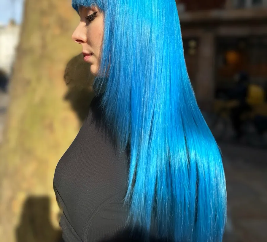 Long, straight electric blue hair with a full fringe, side profile