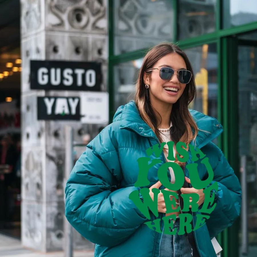 Smiling client in a green jacket by the Gusto Yay sign at Gusto Covent Garden