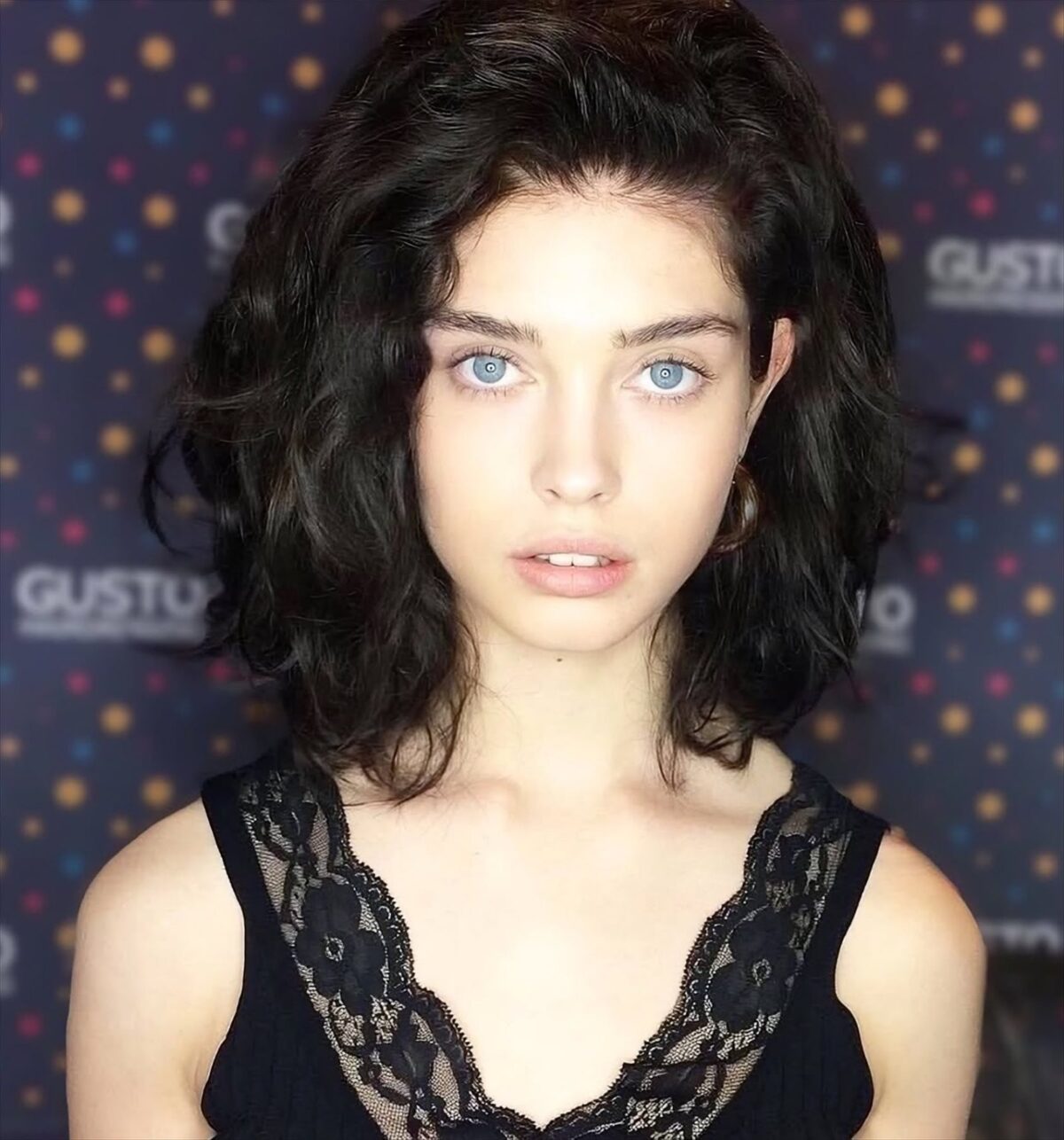 Dark curly bob with face-framing layers at Gusto Hair, London