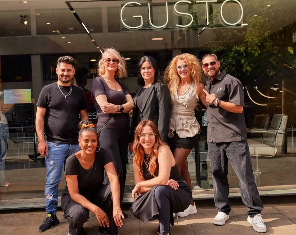 The Gusto team outside the Oxford Street salon under the GUSTO neon sign