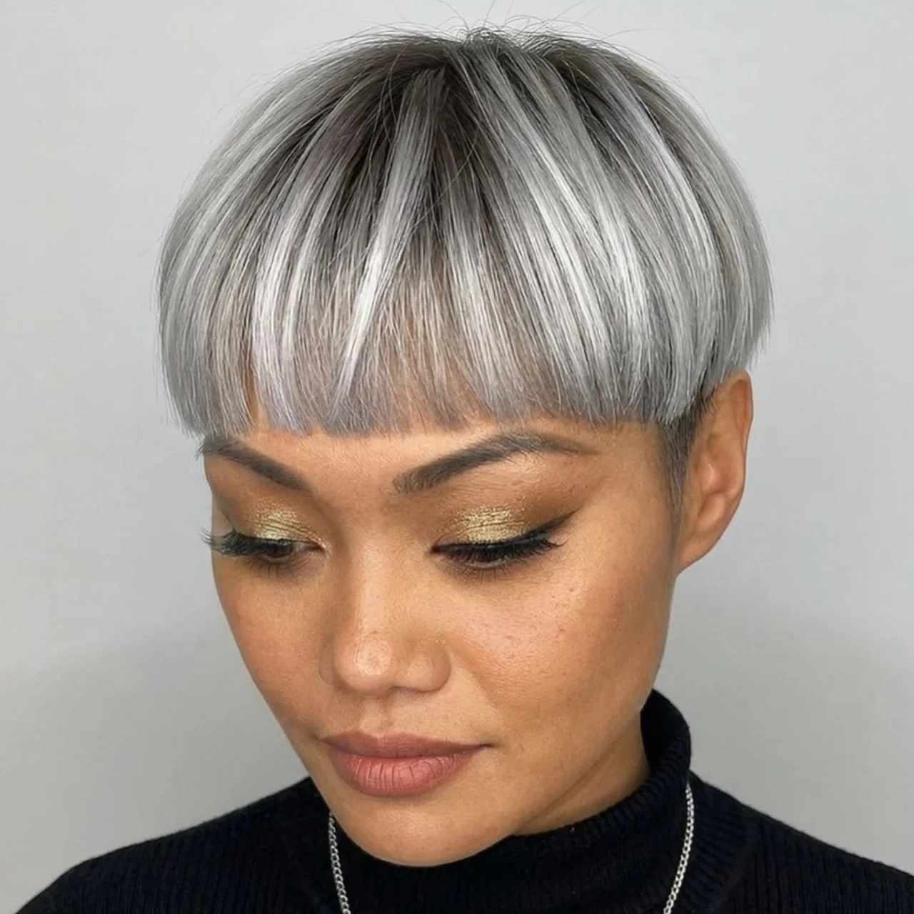 Silver bowl cut with a heavy fringe and dark roots