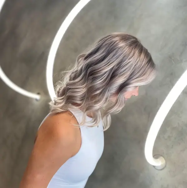 Icy silver balayage on shoulder-length waves at Gusto Hair, London